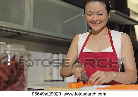 Chinese woman cutting carrots in kitchen View Large Photo Image Stock Image - Chinese woman cutting carrots in kitchen. Fotosearch