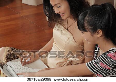 Chinese woman working on computer with daughter View Large Photo Image Stock Photo - Chinese woman working on computer with daughter. Fotosearch