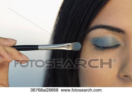 Close up of young woman putting makeup on closed eye. View Large Photo Image Stock Photo - Close up of young woman putting makeup on closed eye.. Fotosearch