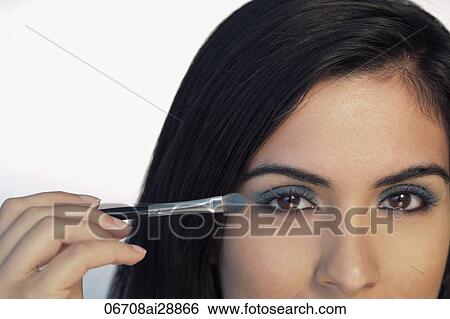 Stock Photograph - Cropped shot of woman putting on eye makeup. Fotosearch