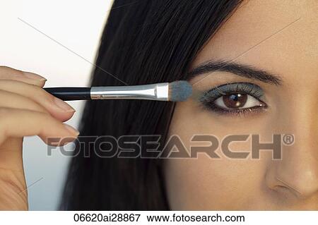 Cropped shot of young woman putting on eye make up. View Large Photo Image Stock Photo - Cropped shot of young woman putting on eye make up.. Fotosearch