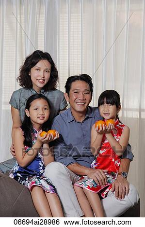 Stock Photograph - Family of four celebrating Chinese New Year. Fotosearch