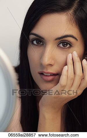 Head shot of beautiful young woman with hand on face View Large Photo Image Stock Photo - Head shot of beautiful young woman with hand on face. Fotosearch