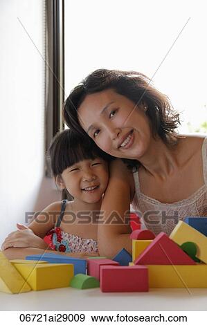 Head shot of mother and daughter smiling with toys in foreground View Large Photo Image Stock Photo - Head shot of mother and daughter smiling with toys in foreground. Fotosearch