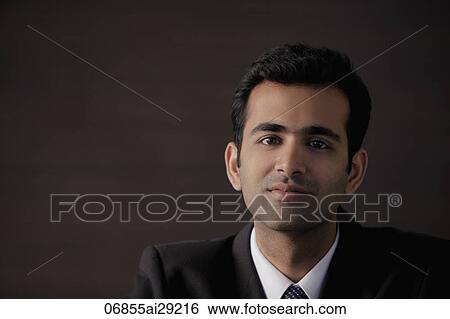 Stock Photograph - Head shot of young man looking at camera. Fotosearch