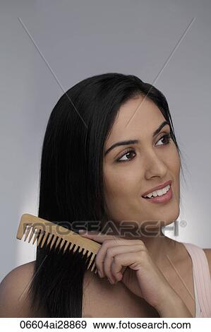 Head shot of young woman combing her long hair View Large Photo Image Stock Photo - Head shot of young woman combing her long hair. Fotosearch