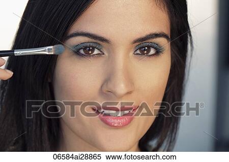 Head shot of young woman putting on make up View Large Photo Image Stock Photography - Head shot of young woman putting on make up. Fotosearch