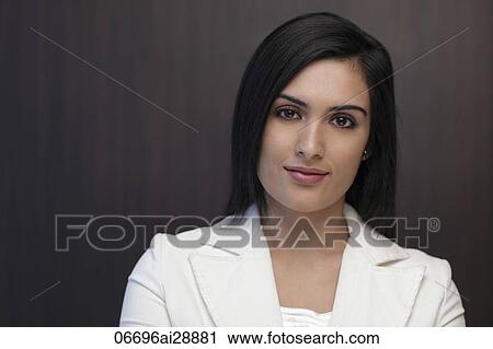 Stock Image - Head shot of young woman wearing suit and smiling. Fotosearch