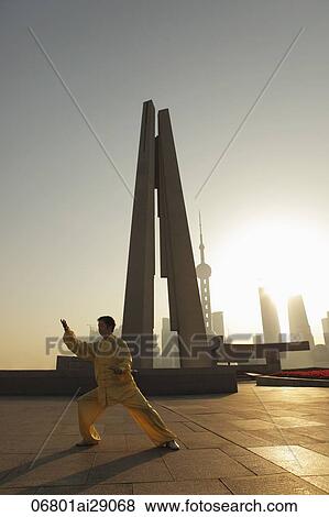 Stock Photo - Man doing tai chi in front of People's Heroes War Memorial, Shanghai, China. Fotosearch