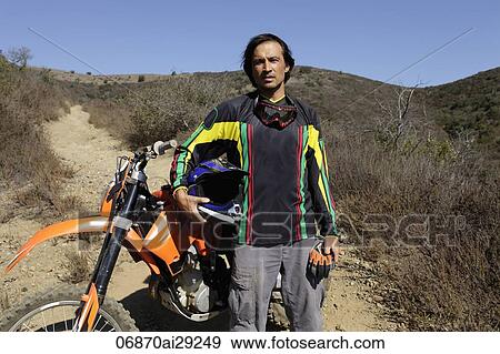Man stands in front of off road motorcycle. View Large Photo Image Stock Photo - Man stands in front of off road motorcycle.. Fotosearch
