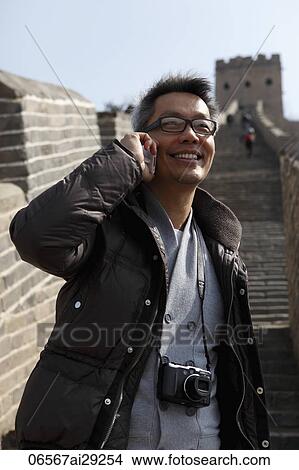 Picture - Man talking on phone on The Great Wall, China. Fotosearch
