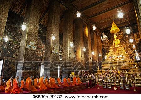 Stock Image - Monks Praying in the main room of Wat Pho, Bangkok, Thailand.. Fotosearch