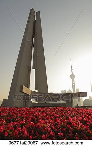 Stock Photo - People's Heroes War Memorial with red flowers in front. Fotosearch