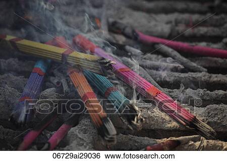 Stock Photograph - Smoking incense sticks at Buddhist temple, China. Fotosearch