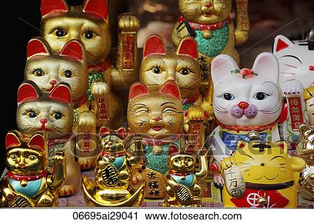 Stock Image - Waving cat statues in Chinese market. Fotosearch