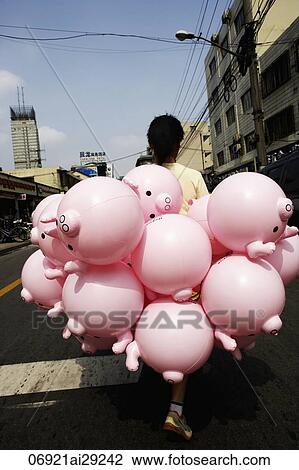 Woman walking with pink pig balloons down the street of Shanghai, China View Large Photo Image Stock Image - Woman walking with pink pig balloons down the street of Shanghai, China. Fotosearch