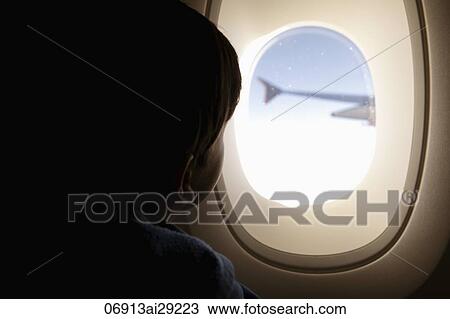 Young boy looking out of plane window View Large Photo Image Stock Image - Young boy looking out of plane window. Fotosearch
