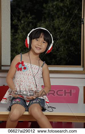 Young Chinese girl wearing headphones and listening to music View Large Photo Image Stock Image - Young Chinese girl wearing headphones and listening to music. Fotosearch