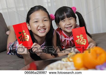 Young Chinese girls holding red envelopes (Hong Bao) and smiling View Large Photo Image Stock Photo - Young Chinese girls holding red envelopes (Hong Bao) and smiling. Fotosearch