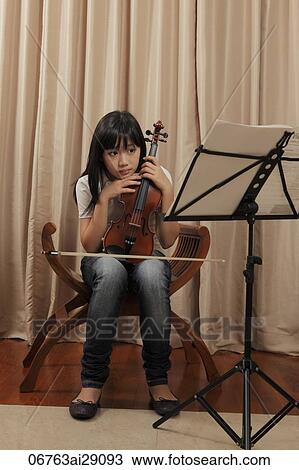 Young girl holding violin and looking sad View Large Photo Image Stock Image - Young girl holding violin and looking sad. Fotosearch