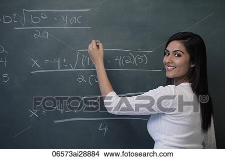 Young woman writing math equation on chalk board and smiling View Large Photo Image Picture - Young woman writing math equation on chalk board and smiling. Fotosearch