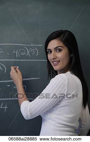 Young woman writing on chalk board and smiling. View Large Photo Image Stock Photography - Young woman writing on chalk board and smiling.. Fotosearch