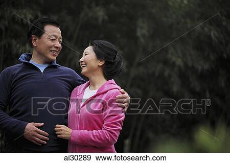 A senior couple in sweatsuits looking at each other and smiling View Large Photo Image Stock Photo - A senior couple in sweatsuits looking at each other and smiling. Fotosearch