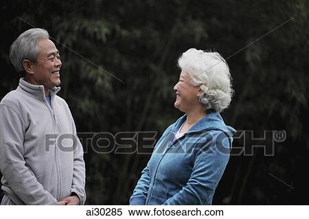 Stock Photography - A senior couple in sweatsuits talking together. Fotosearch