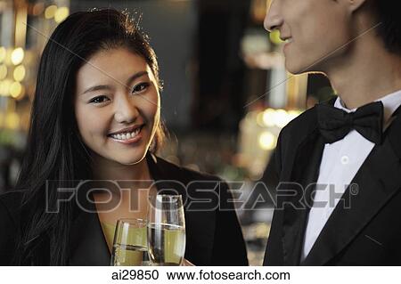 An elegantly dressed couple toasting each other with champagne glasses View Large Photo Image Stock Image - An elegantly dressed couple toasting each other with champagne glasses. Fotosearch