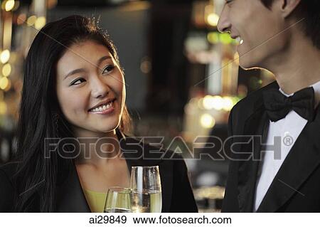 An elegantly dressed couple toasting with champagne glasses View Large Photo Image Stock Photo - An elegantly dressed couple toasting with champagne glasses. Fotosearch