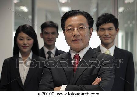 Businessman standing in front of his colleagues View Large Photo Image Stock Image - Businessman standing in front of his colleagues. Fotosearch