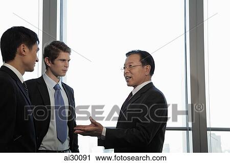 Businessman talking to younger excutives View Large Photo Image Stock Image - Businessman talking to younger excutives. Fotosearch
