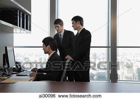 Businessmen working together in office View Large Photo Image Stock Photograph - Businessmen working together in office. Fotosearch
