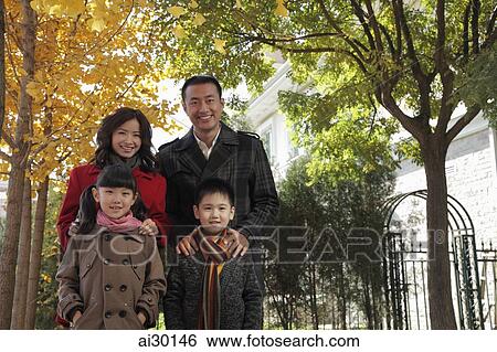 Family of four standing together in front of their house View Large Photo Image Stock Photograph - Family of four standing together in front of their house. Fotosearch