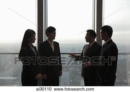 Four businesspeople standing in front of a window View Large Photo Image Stock Image - Four businesspeople standing in front of a window. Fotosearch
