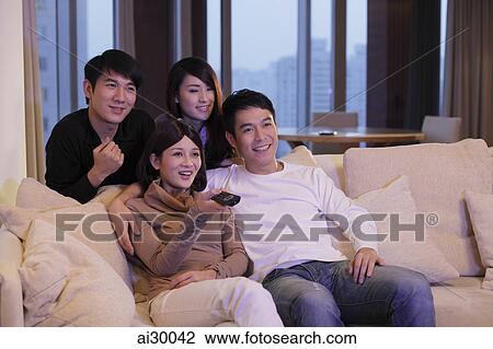 Stock Image - Four people watching TV together. Fotosearch
