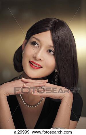 Stock Photo - Head shot of a beautiful woman wearing diamond jewelry. Fotosearch
