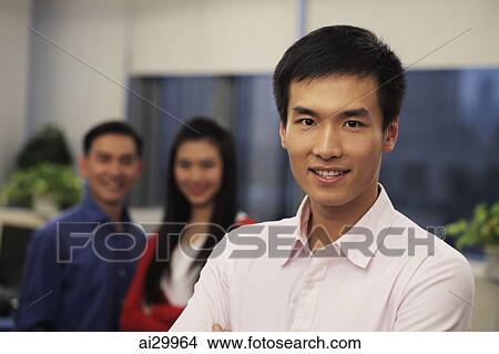 Head shot of man with two colleagues smiling behind him View Large Photo Image Picture - Head shot of man with two colleagues smiling behind him. Fotosearch