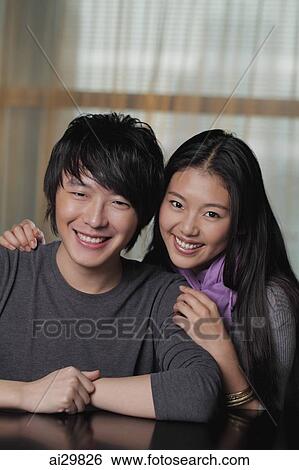 Stock Photograph - Head shot of young couple smiling together. Fotosearch