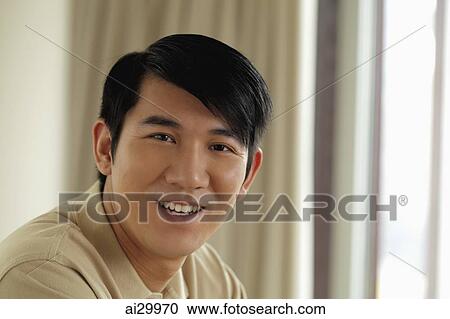 Stock Image - Head shot of young man smiling at camera. Fotosearch