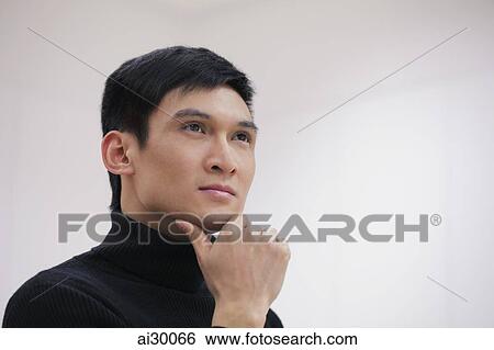 Head shot of young man with hand on chin View Large Photo Image Stock Photograph - Head shot of young man with hand on chin. Fotosearch