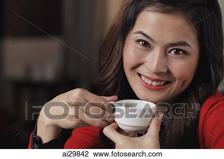 Head shot of young woman holding coffee cup View Large Photo Image Stock Image - Head shot of young woman holding coffee cup. Fotosearch