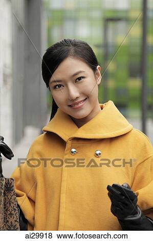 Head shot of young woman holding shopping bags and smiling View Large Photo Image Stock Photo - Head shot of young woman holding shopping bags and smiling. Fotosearch