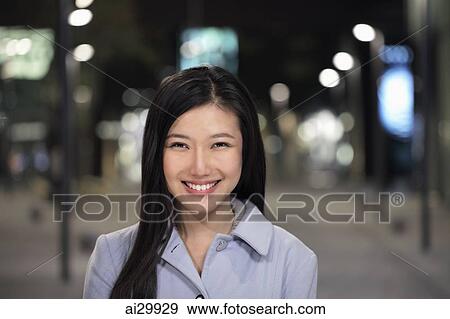 Head shot of young woman smiling on the street at night View Large Photo Image Stock Photo - Head shot of young woman smiling on the street at night. Fotosearch