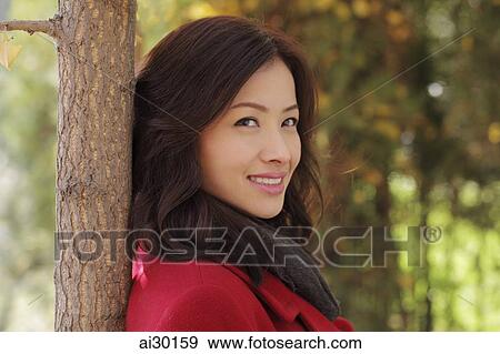 Head shot of young woman under a tree View Large Photo Image Stock Photo - Head shot of young woman under a tree. Fotosearch