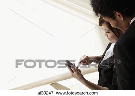 Man and woman looking at phone together View Large Photo Image Stock Photo - Man and woman looking at phone together. Fotosearch