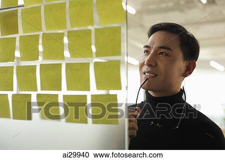 man looking at sticky notes and smiling View Large Photo Image Stock Image - man looking at sticky notes and smiling. Fotosearch