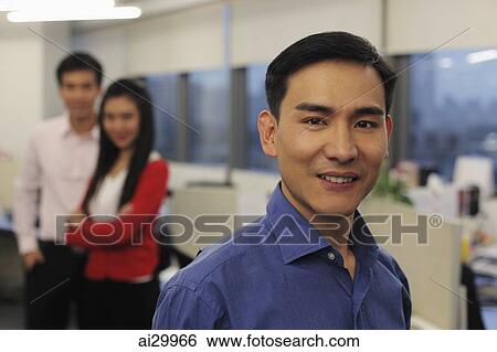 Man standing in front of colleagues at work View Large Photo Image Stock Photograph - Man standing in front of colleagues at work. Fotosearch