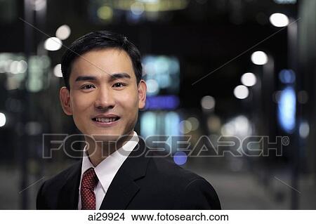 Man wearing business suit standing on the street at night View Large Photo Image Picture - Man wearing business suit standing on the street at night. Fotosearch