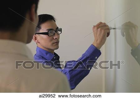 Man writing on white board while another looks on View Large Photo Image Stock Image - Man writing on white board while another looks on. Fotosearch